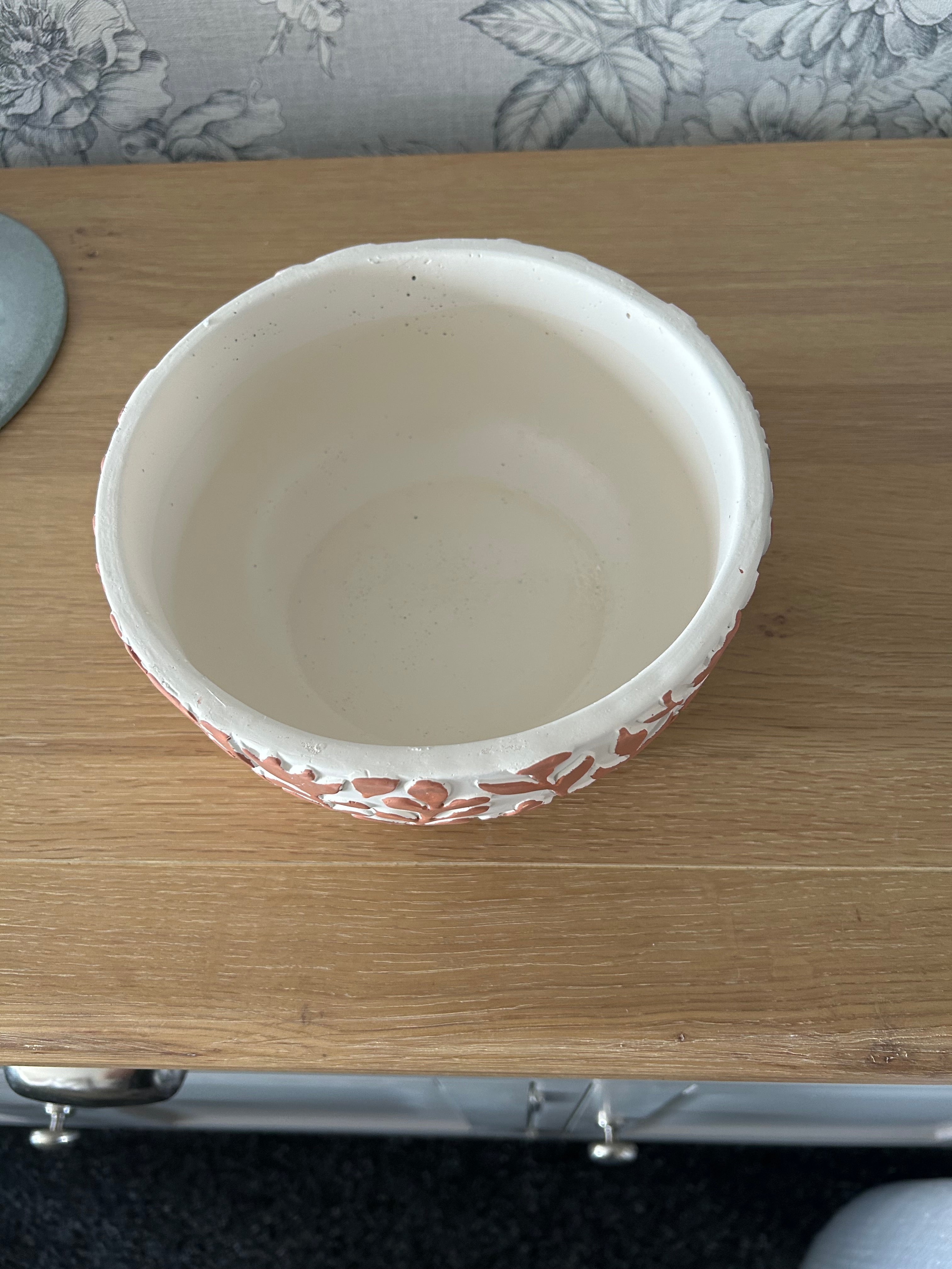 White ceramic bowl with decorative rim on a wooden surface