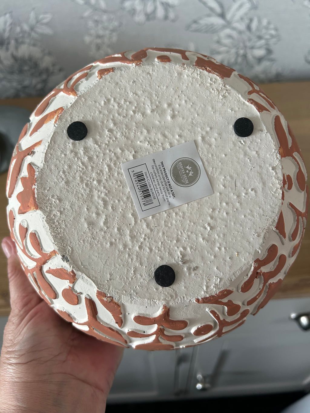 Decorative pot with a label on a textured surface