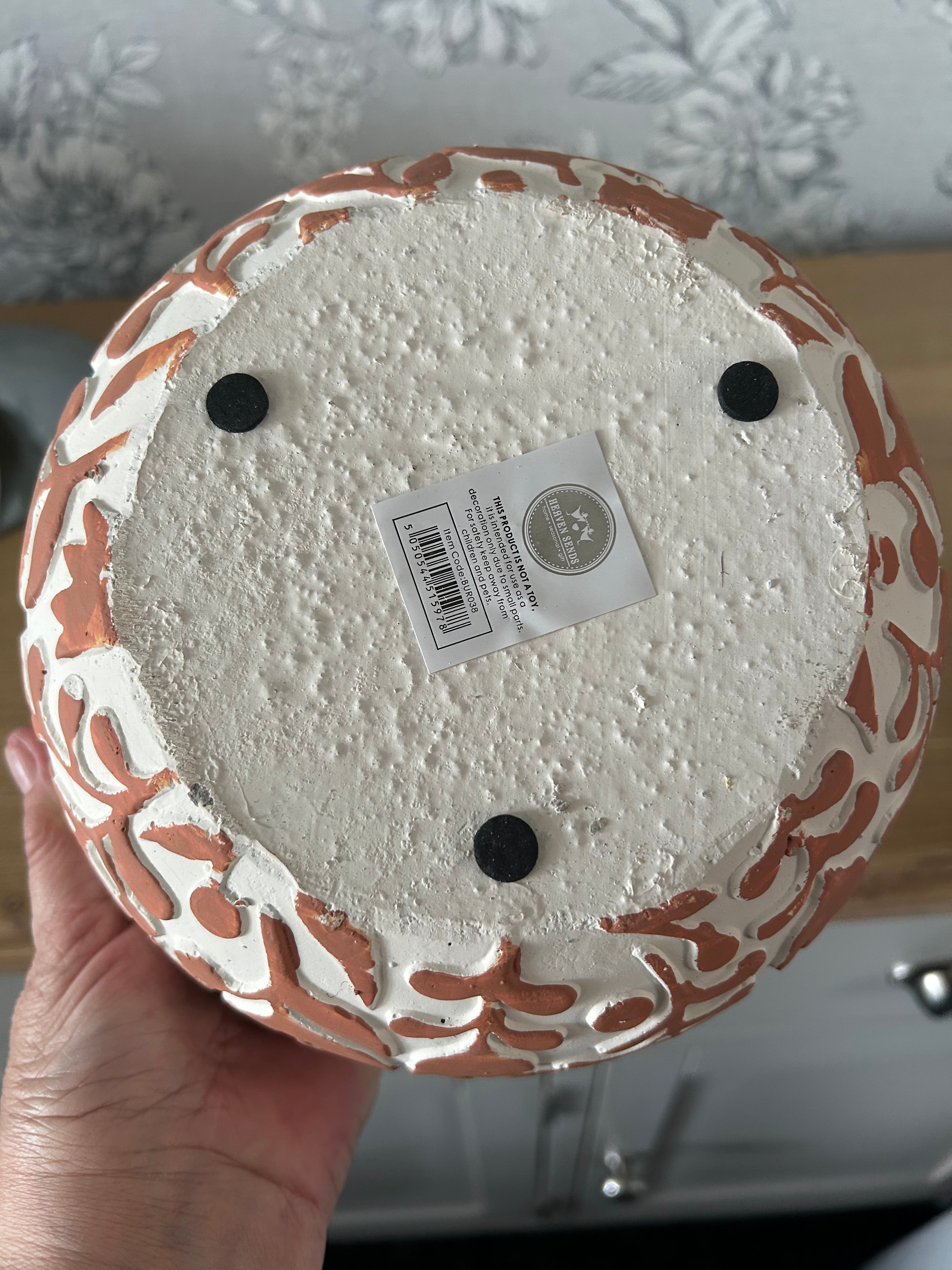Decorative pot with a label on a textured surface