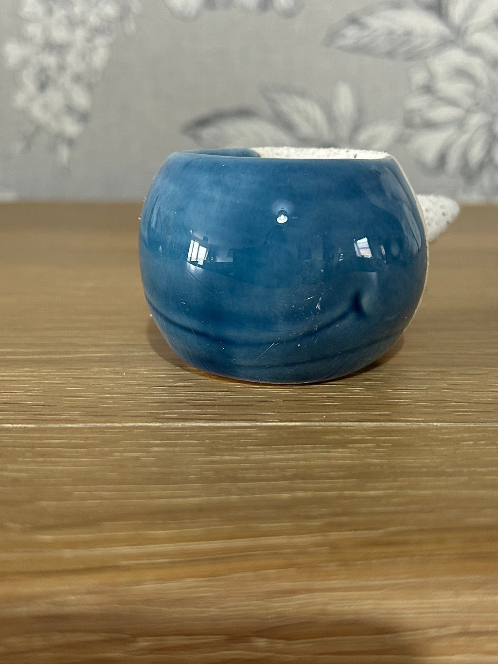 Blue ceramic whale on a wooden surface