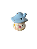 Small ceramic mushroom house with a blue cap on a white background