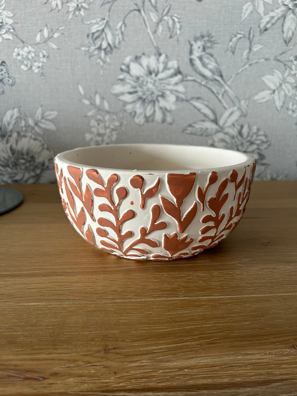 Ceramic bowl with floral patterns on a wooden surface