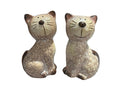 Two ceramic cat figurines on a table with a blurred background