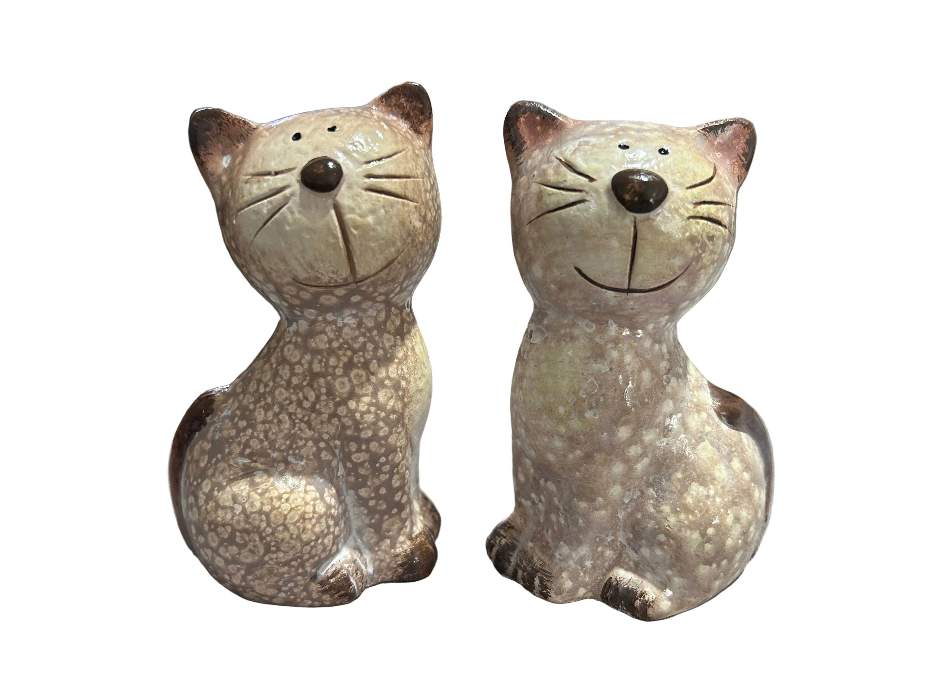 Two ceramic cat figurines on a table with a blurred background