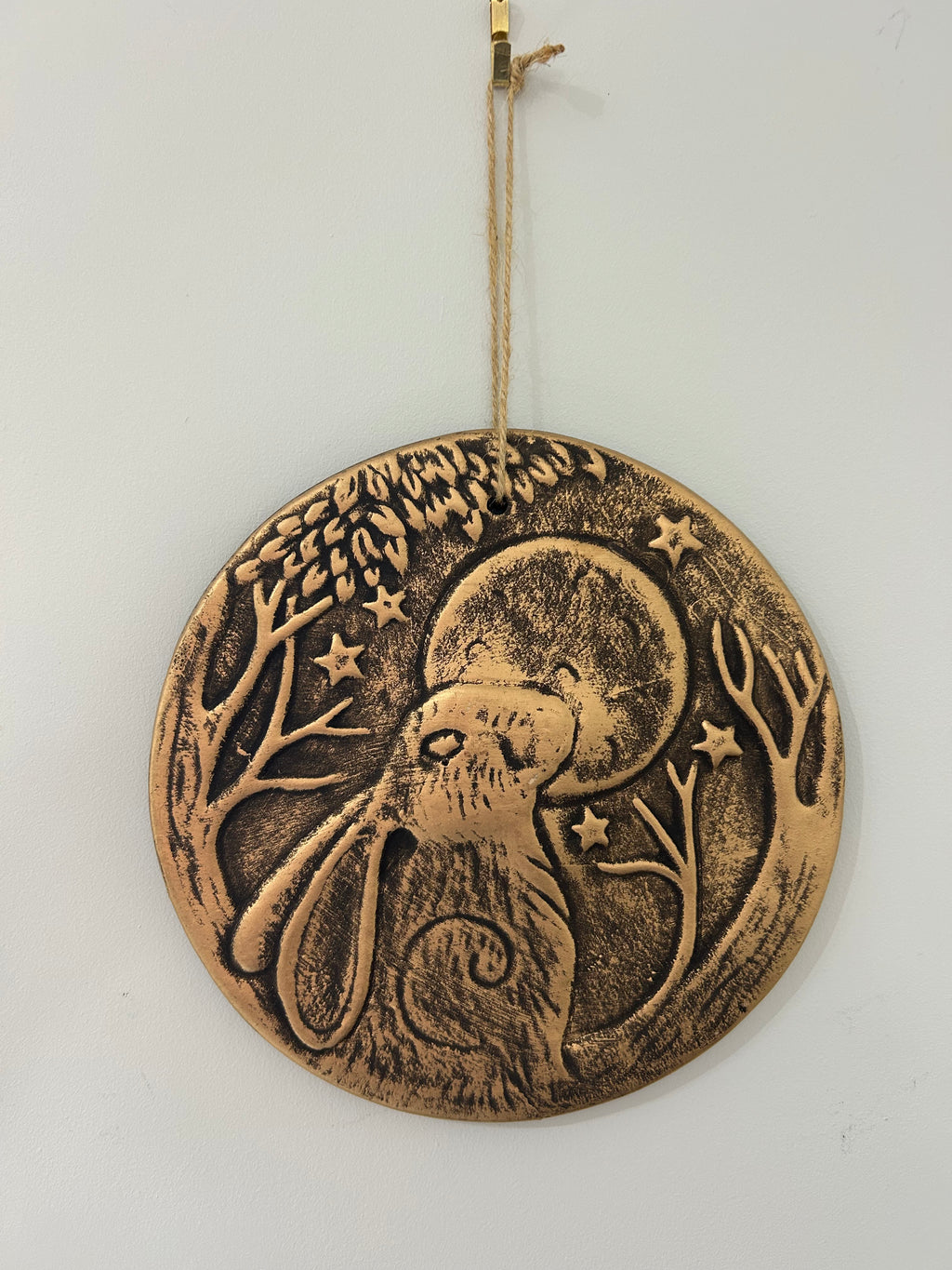 Bronze-colored decorative wall hanging with a hare and moon design 